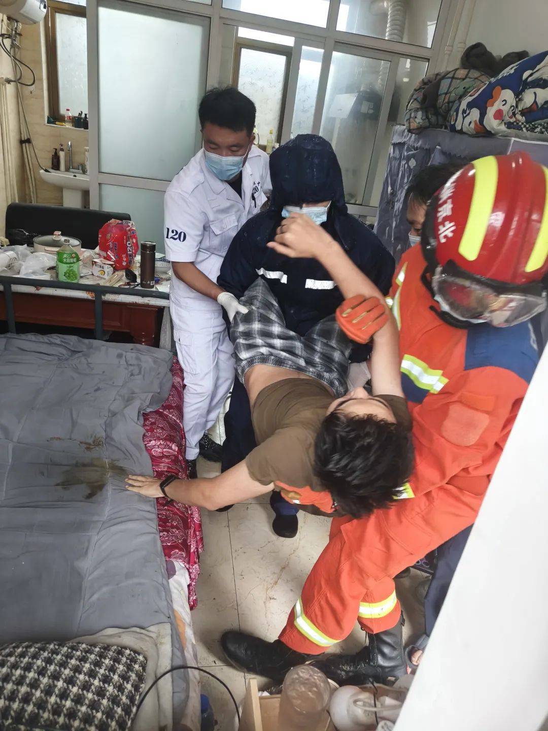 大雨中医疗和消防人员架起梯子救治患者